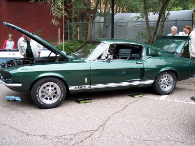 1972 Ford Ranchero - A classic green Ford Mustang Shelby GT500 is displayed with its hood and trunk open, revealing its engine and interior.