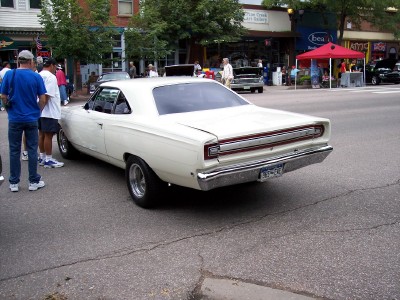 1972 Ford Ranchero - White 1968 Plymouth Road Runner parked on street with people nearby.