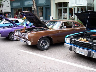 1972 Ford Ranchero - A collection of vintage automobiles are lined up on a street, their engines exposed for viewing.