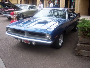 1972 Ford Ranchero - A blue 1970 Plymouth Barracuda is parked outside, with another vehicle in the background.