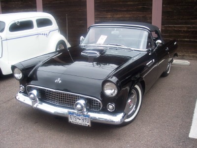 1972 Ford Ranchero - A black 1955 Ford Thunderbird convertible is parked next to a white car. The license plate reads 679-HYU.