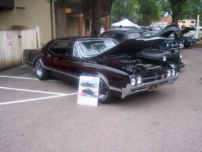 1972 Ford Ranchero - A black coupe sits on display with its hood open, revealing the engine bay.