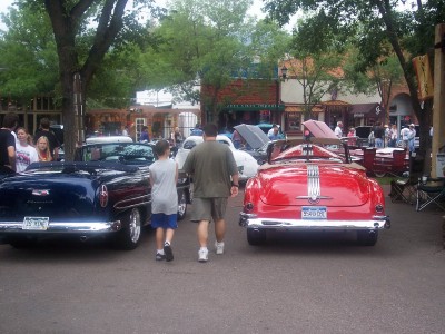 1972 Ford Ranchero - Two convertibles are parked on a street with people around them.
