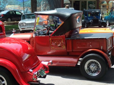 1972 Ford Ranchero - A vintage red pickup truck with a black convertible top is parked next to another red vehicle.