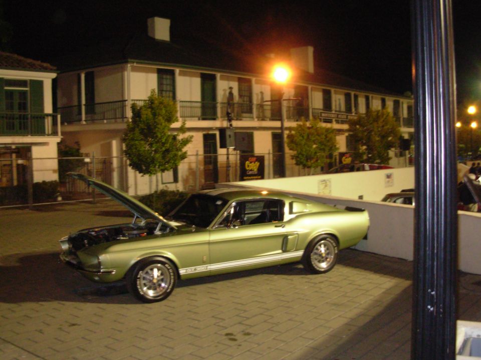 Green 1967 Ford Mustang Fastback with hood open, parked at night