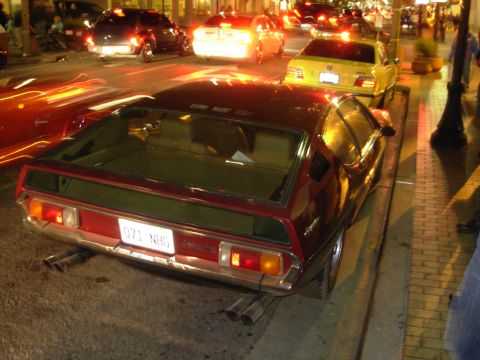 1995 Ford Taurus - A maroon Lamborghini Espada is parked on a city street at night, with other cars visible in the background.