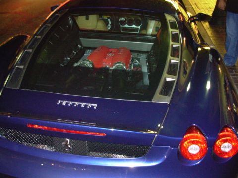 1995 Ford Taurus - Rear view of a blue Ferrari, its exposed red engine through the glass rear decklid.