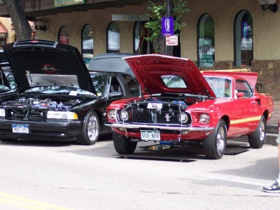 1972 Ford Ranchero - Two classic American cars, a 1969 Ford Mustang Mach 1 and a Chevrolet Impala, displayed with hoods up.