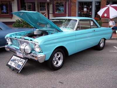 1972 Ford Ranchero - A light blue coupe, likely from the early 1960s, is parked with its hood open next to another vehicle.