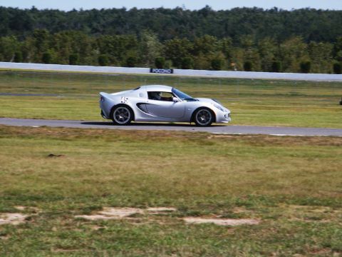 2001 Mercury Grand Marquis - A silver Lotus Elise with racing number 45 navigates a turn on a sunny day at a race track.