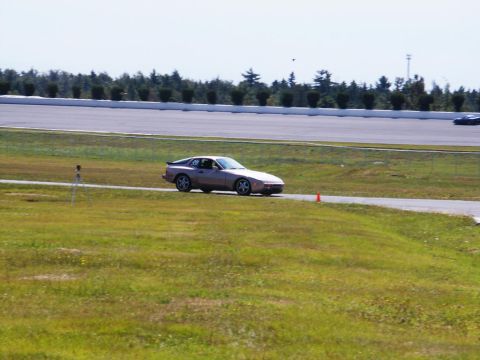 2001 Mercury Grand Marquis - A Porsche 944 drives on a race track on a sunny day.