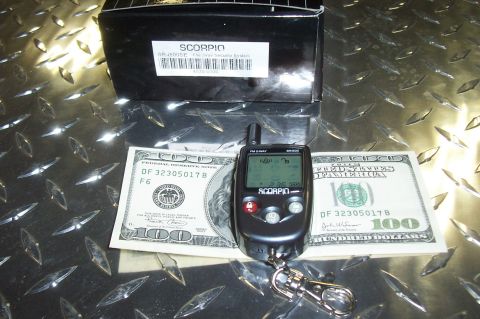 1994 Ford F-150 - Scorpio car alarm remote and box are displayed with US currency on a diamond plate surface.
