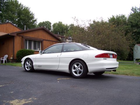 1993 Ford Probe - A white 1993 Ford Probe GT is parked in a driveway next to a house.