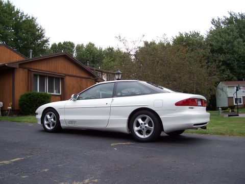 1993 Ford Probe - A white 1993 Ford Probe GT is parked on a driveway in front of a house.