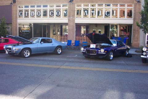 1970 Chevrolet Camaro - A blue 1970 Chevrolet Camaro is displayed with its hood open, parked alongside another muscle car.