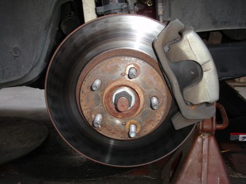 1995 Ford Taurus - Close-up of a car's front brake assembly, showing the rotor and caliper.
