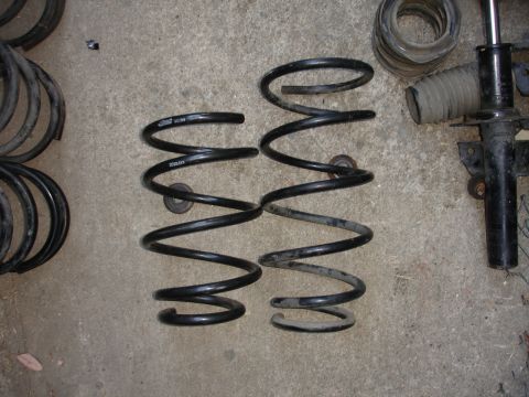 1995 Ford Taurus - Car suspension parts including coil springs and a shock absorber strut assembly.