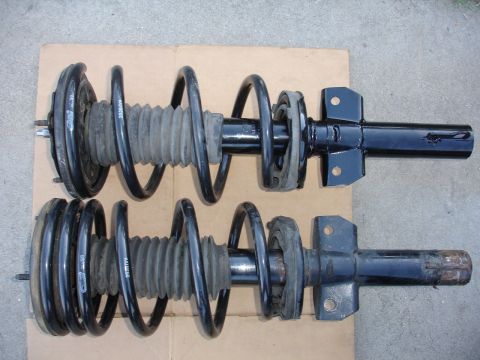 1995 Ford Taurus - Front strut assemblies with coiled springs and rubber bellows are shown from a top-down perspective.
