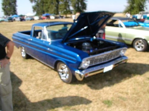 1967 Ford Ranchero - A blue 1966 Ford Ranchero is displayed with its hood open at an outdoor car show.