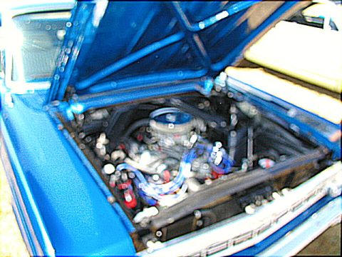 1967 Ford Ranchero - The engine bay of a blue 1967 Ford Ranchero, a V8 engine with prominent blue spark plug wires.