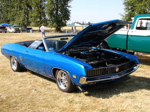 1967 Ford Ranchero - A blue 1970 Ford Torino convertible is displayed with its hood open next to a green pickup truck.