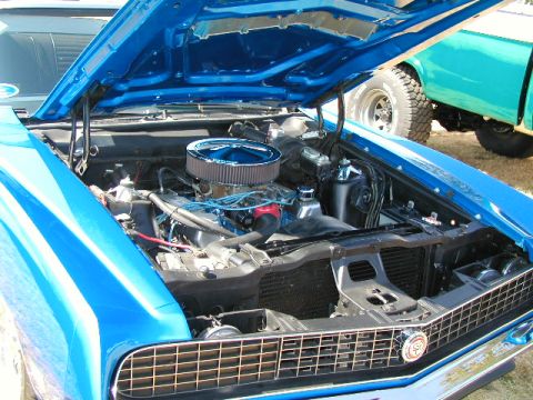 1967 Ford Ranchero - Engine bay of a blue 1967 Ford Ranchero, a chrome air cleaner and a detailed front grille.