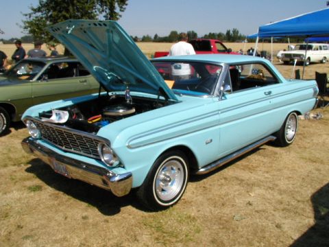 1967 Ford Ranchero - Light blue 1965 Ford Falcon coupe at a car show, hood raised to show the engine bay.