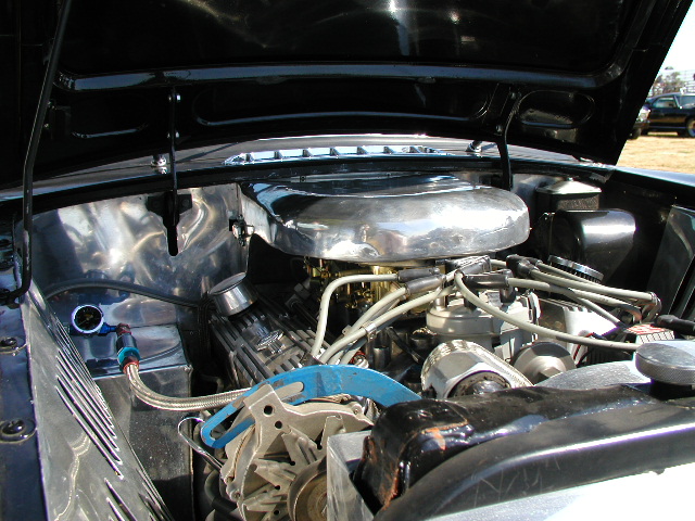 V8 engine bay with polished oval air cleaner and white plug wires