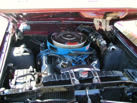 1967 Ford Ranchero - The engine compartment of a Ford vehicle is shown, a V8 engine with a prominent air filter assembly.
