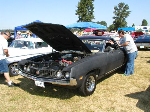 1967 Ford Ranchero - A dark-colored 1968 Ford Ranchero is displayed with its hood open at an outdoor car show.