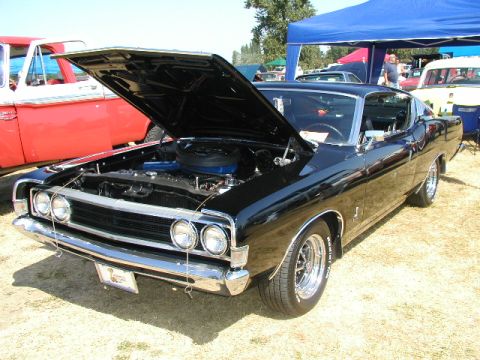 1967 Ford Ranchero - A black 1968 Ford Torino GT is displayed with its hood open at a car show.