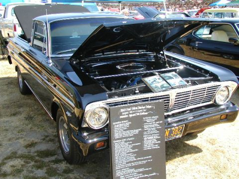 1967 Ford Ranchero - A black 1965 Ford Falcon Ranchero is displayed with its hood open, revealing the engine and an information board detailing its features.