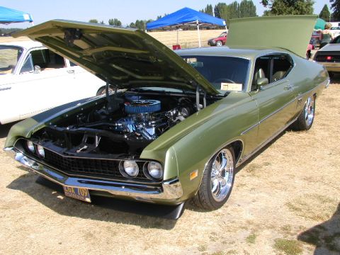 1967 Ford Ranchero - A green 1970 Ford Torino GT is displayed with its hood open at an outdoor car show.
