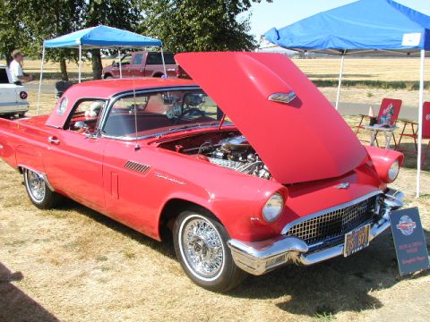 1967 Ford Ranchero - A red 1957 Ford Thunderbird is displayed with its hood open at an outdoor car show.