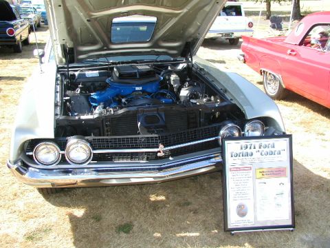 1967 Ford Ranchero - A 1971 Ford Torino Cobra is displayed with its hood open, revealing the engine and a descriptive sign.