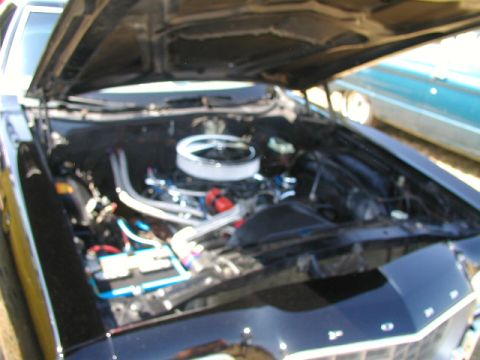 1967 Ford Ranchero - The engine compartment of a car is open, revealing the motor and various components.