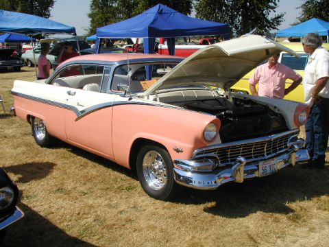 1967 Ford Ranchero - A two-tone pink and white 1956 Ford Fairlane Crown Victoria is displayed with its hood open at a car show.