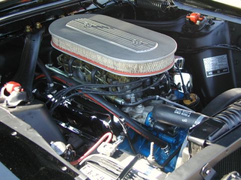 1967 Ford Ranchero - The engine bay of a 1967 Ford Ranchero shows a V8 engine with a chrome air cleaner and blue valve covers.