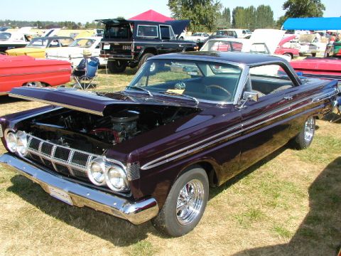 1967 Ford Ranchero - A dark purple 1964 Mercury Comet is displayed with its hood open at an outdoor car show.