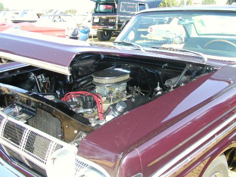 1967 Ford Ranchero - The engine bay of a 1967 Ford Ranchero is displayed, a V8 engine with a prominent chrome air cleaner.