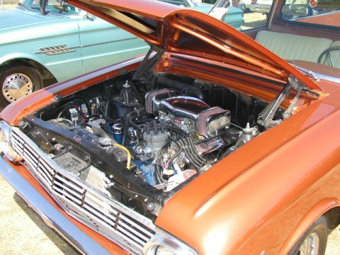 1967 Ford Ranchero - Engine bay of a 1967 Ford Ranchero, showing custom chrome air intake and orange metallic paint.