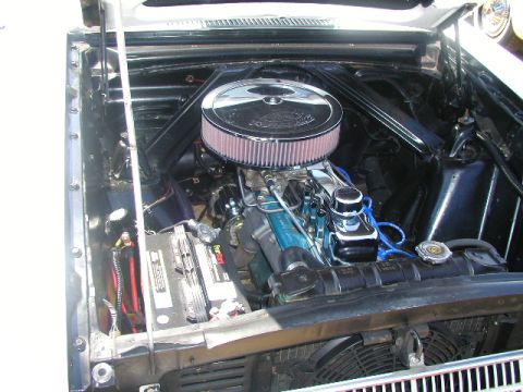 1967 Ford Ranchero - The engine bay of a 1967 Ford Falcon shows a V8 engine with a chrome air cleaner and a freshly installed battery.