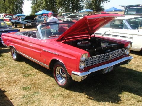 1967 Ford Ranchero - A red 1965 Mercury Comet convertible is displayed with its hood open at an outdoor car show.