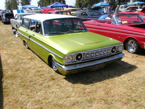 1967 Ford Ranchero - A vintage station wagon with a distinctive grille and chrome trim is displayed at an outdoor car show.