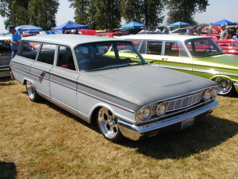 1967 Ford Ranchero - A gray 1961 station wagon with custom wheels is parked at a car show next to a lime green car.