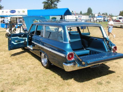 1967 Ford Ranchero - Blue 1963 Ford Falcon Squire station wagon at a car show with tailgate and doors open.