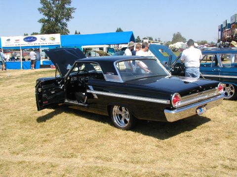 1967 Ford Ranchero - A black 1963 Ford Galaxie 500 is displayed with its doors and hood open at an outdoor car show.