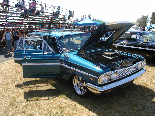 Teal 1962 Ford Falcon Squire wagon, hood open, driver's door ajar
