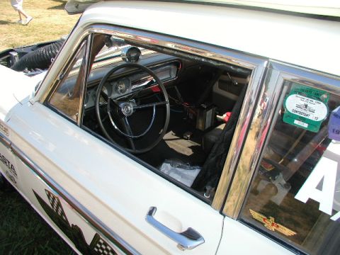 1967 Ford Ranchero - The interior of a classic Ford Falcon shows its steering wheel, dashboard, and a contest sticker on the window.