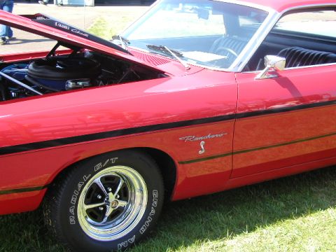 1967 Ford Ranchero - A red 1967 Ford Ranchero is displayed with its hood open, revealing the engine bay.